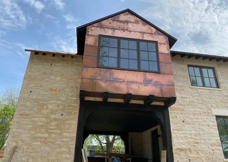 Copper metal panel facade on a stone building for Skylight Installation in Joshua